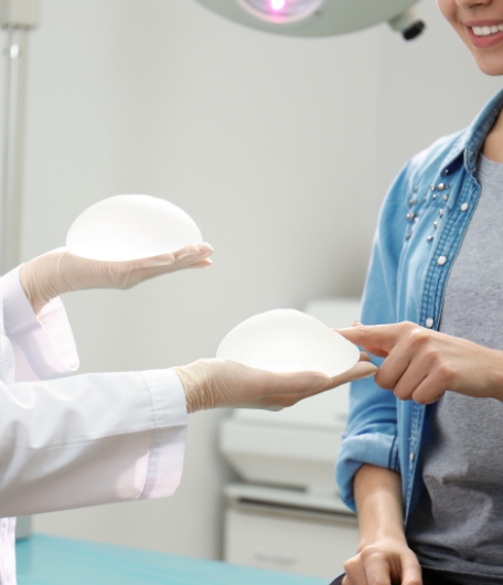 Patientin wählt Brustimplantat beim Beratungsgespräch