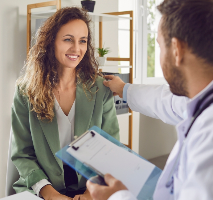 Arzt-Patienten-Gespräch: Arzt legt Patientin Hand auf die Schulter